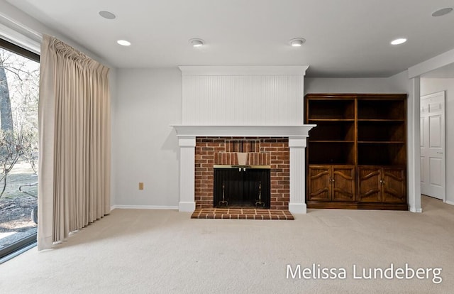 unfurnished living room with carpet flooring, recessed lighting, a fireplace, and baseboards