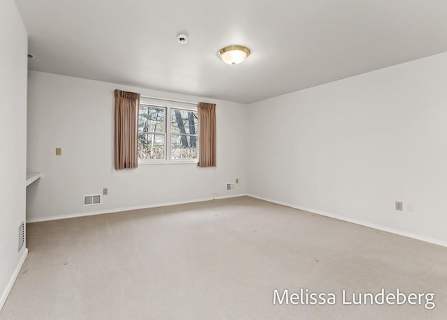 spare room featuring visible vents, baseboards, and carpet flooring