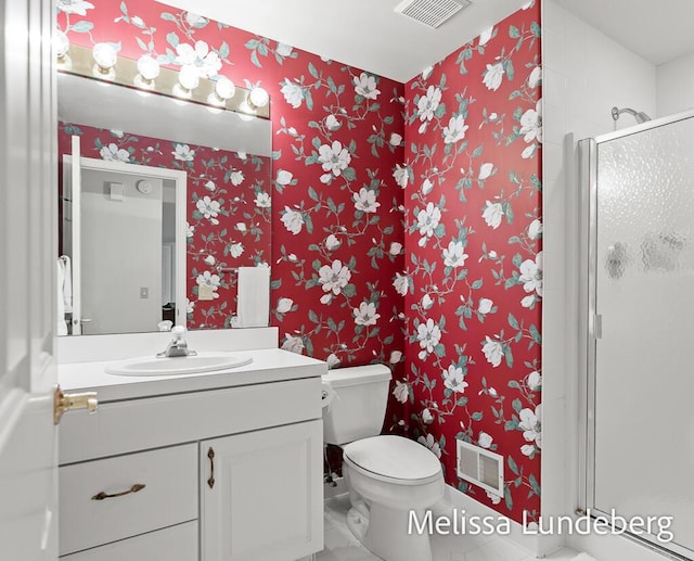 bathroom with visible vents, vanity, a shower stall, and wallpapered walls