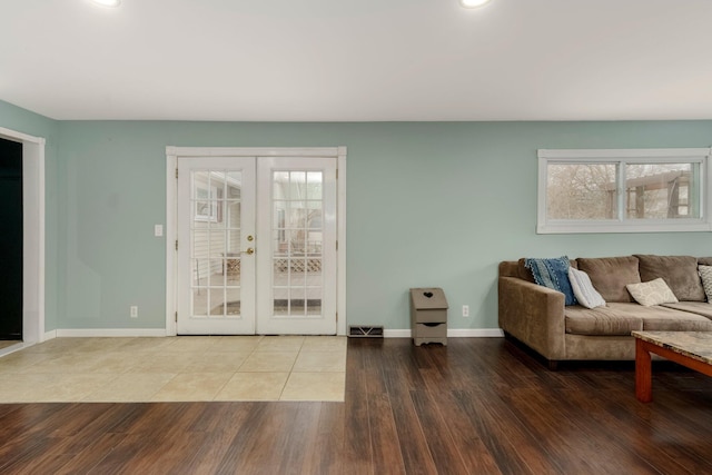 living area with visible vents, french doors, baseboards, and wood finished floors