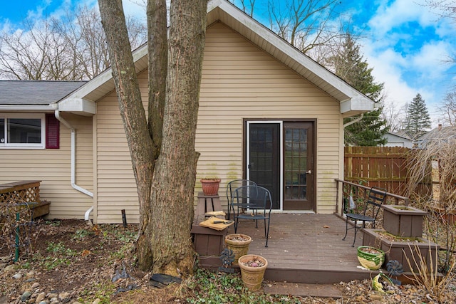 rear view of house featuring fence and a wooden deck