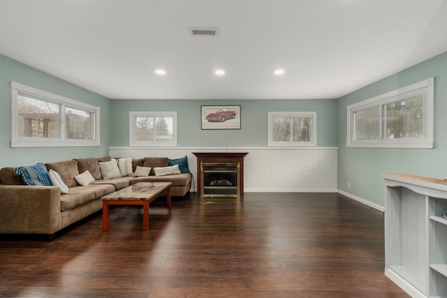 living room featuring visible vents, baseboards, recessed lighting, a fireplace, and dark wood-style floors