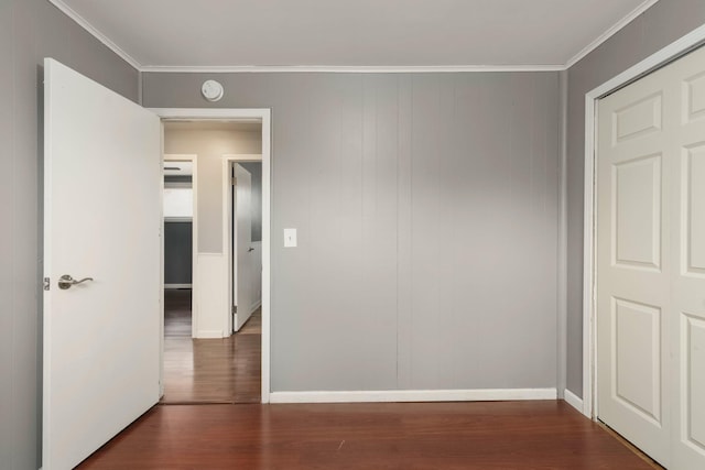 interior space with baseboards, dark wood-type flooring, and crown molding