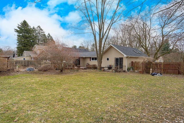 back of house with a lawn and fence