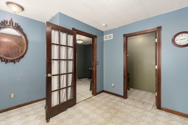 unfurnished room featuring baseboards, visible vents, carpet floors, and a textured ceiling