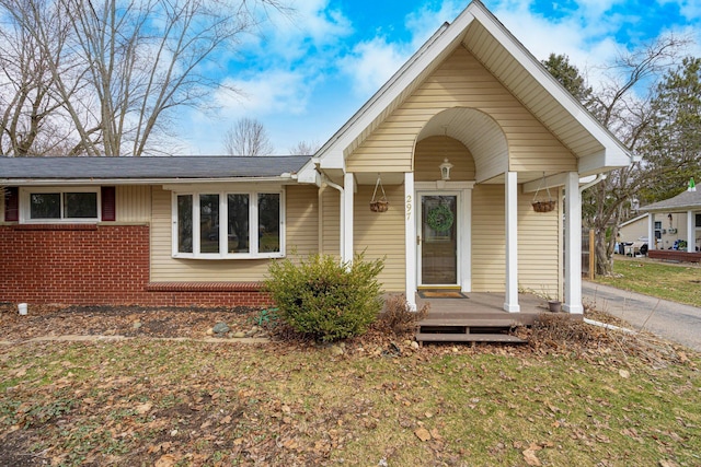 view of front facade featuring brick siding and a porch