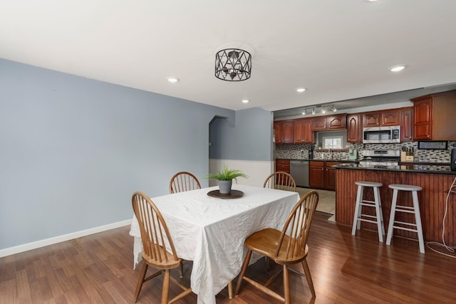 dining area featuring recessed lighting, baseboards, and dark wood-style flooring