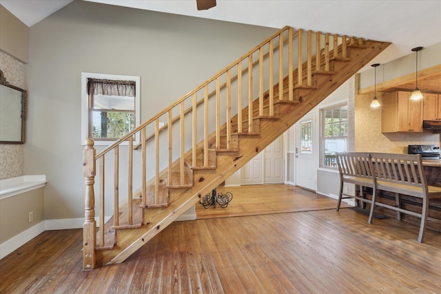 stairs featuring vaulted ceiling, baseboards, and hardwood / wood-style floors