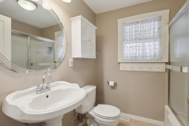 bathroom with a sink, an enclosed shower, baseboards, and toilet