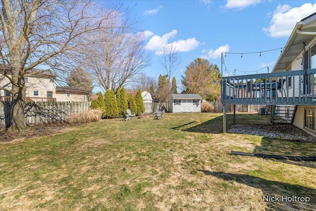 view of yard with fence, stairs, an outdoor structure, a storage unit, and a deck