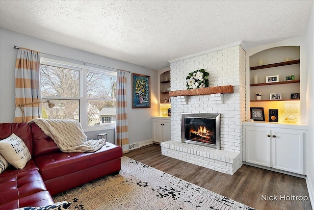 living area featuring dark wood finished floors, a fireplace, visible vents, and a textured ceiling