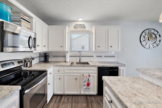 kitchen featuring a sink, decorative backsplash, white cabinets, and stainless steel appliances