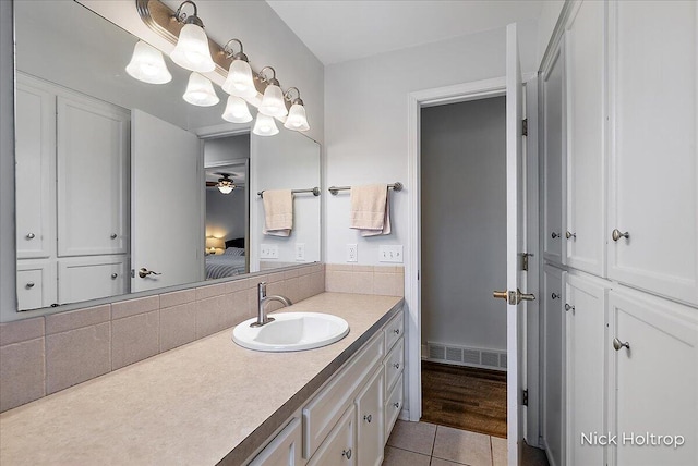 ensuite bathroom with visible vents, ensuite bathroom, backsplash, tile patterned flooring, and vanity