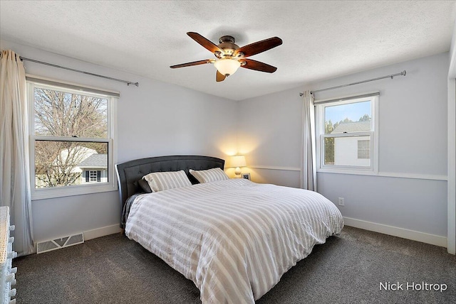 carpeted bedroom with visible vents, baseboards, a textured ceiling, and ceiling fan