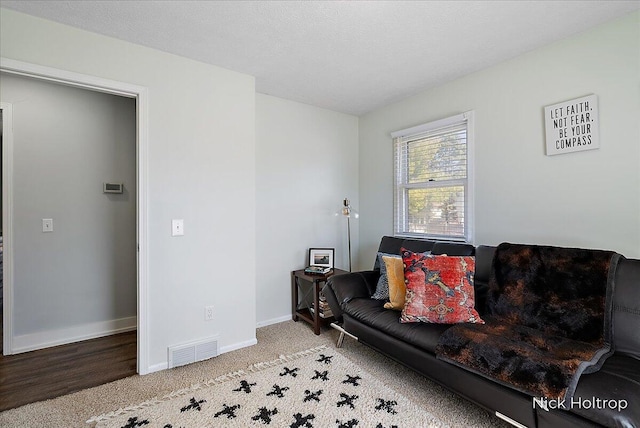 carpeted living room featuring visible vents and baseboards