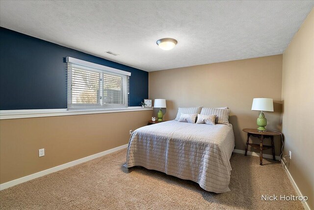 bedroom with visible vents, a textured ceiling, and baseboards