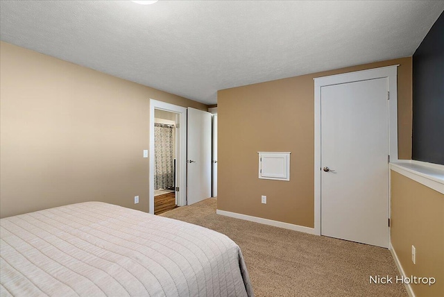 carpeted bedroom with a textured ceiling and baseboards