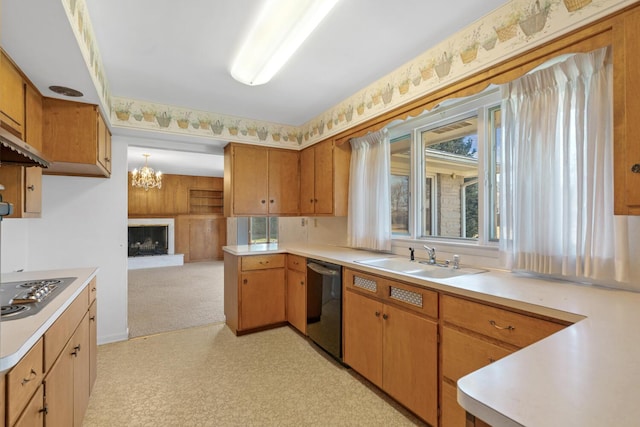 kitchen featuring a fireplace with raised hearth, dishwasher, light countertops, and a sink