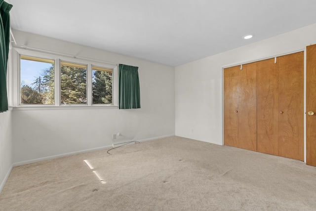 unfurnished bedroom featuring recessed lighting, a closet, baseboards, and carpet