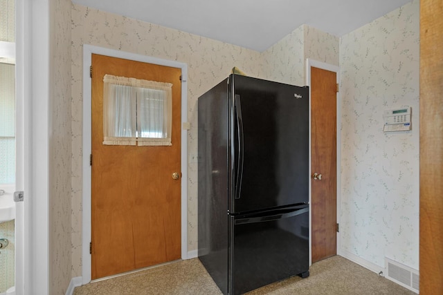 kitchen featuring wallpapered walls, baseboards, visible vents, and freestanding refrigerator