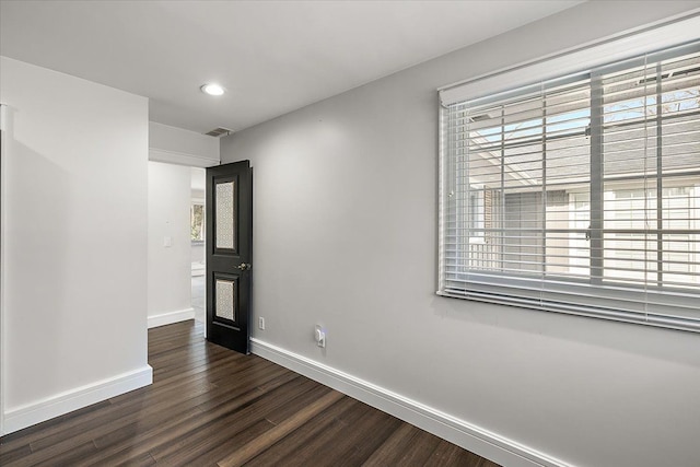 spare room featuring recessed lighting, visible vents, baseboards, and dark wood-style flooring