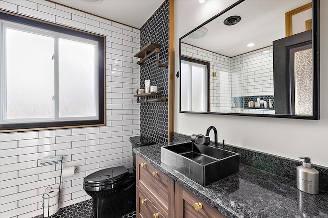 full bath with toilet, vanity, tile patterned floors, tile walls, and a shower