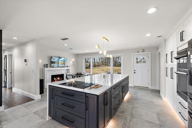 kitchen with visible vents, light countertops, recessed lighting, white cabinetry, and black electric cooktop