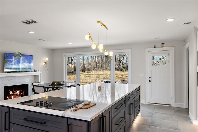 kitchen with visible vents, pendant lighting, recessed lighting, a premium fireplace, and black electric stovetop