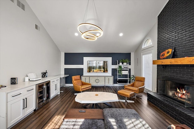 living area with visible vents, beverage cooler, a fireplace, lofted ceiling, and dark wood-style flooring