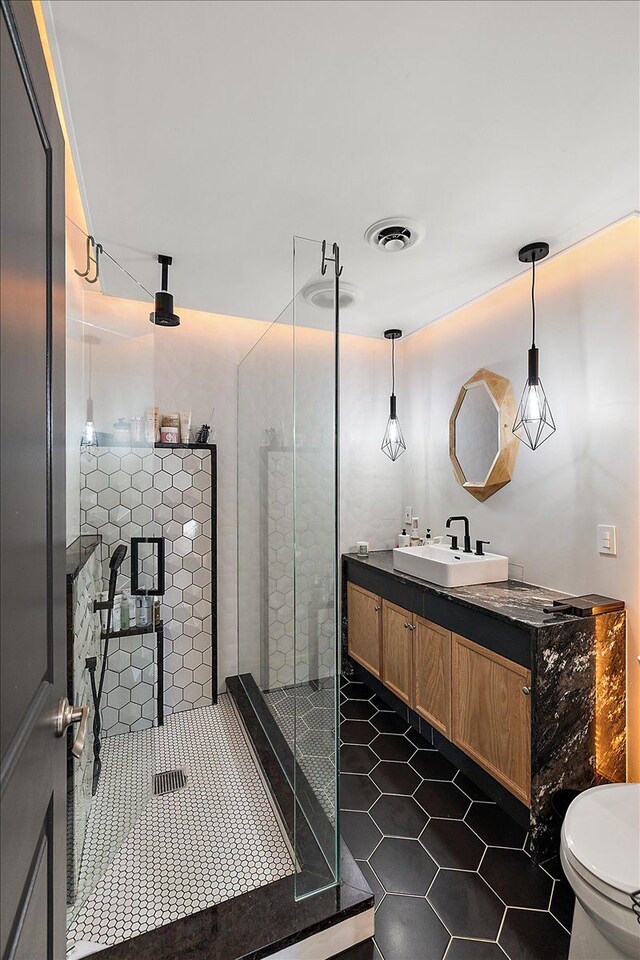 full bath featuring tile patterned flooring, visible vents, a shower stall, toilet, and vanity