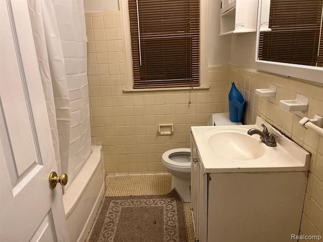 bathroom featuring tile patterned flooring, tile walls, toilet, shower / tub combo, and vanity