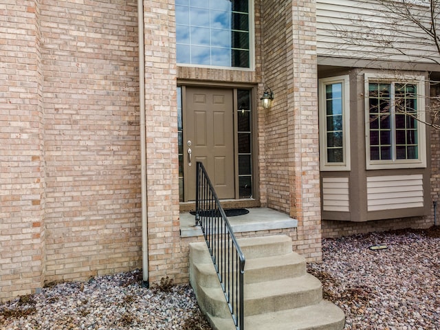 entrance to property featuring brick siding