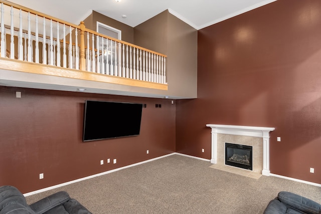 unfurnished living room with baseboards, carpet floors, a towering ceiling, and a tiled fireplace