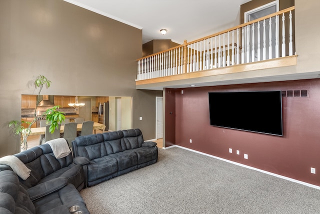 living area with visible vents, ornamental molding, carpet, a high ceiling, and baseboards