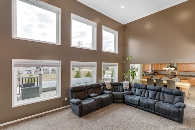 living room with visible vents, crown molding, baseboards, light carpet, and a towering ceiling