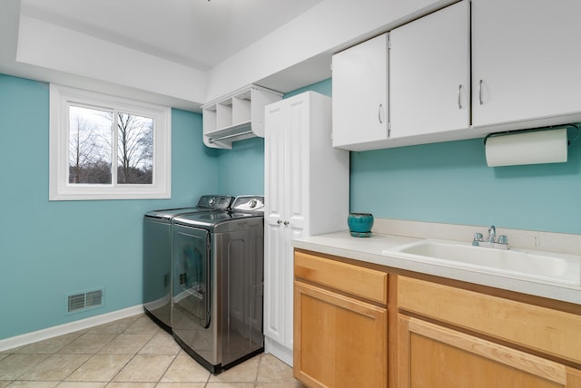 laundry room featuring visible vents, a sink, washer and dryer, cabinet space, and light tile patterned floors