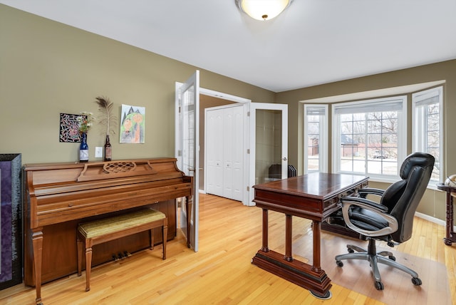 office area with light wood-style floors and baseboards