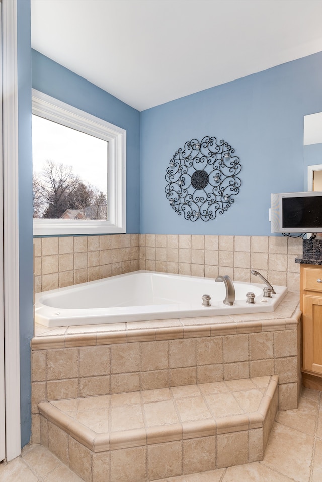 full bathroom featuring a bath and vanity