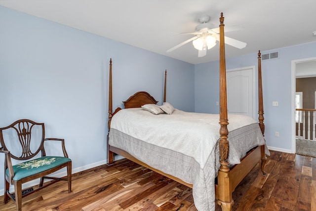 bedroom with a ceiling fan, wood finished floors, visible vents, and baseboards