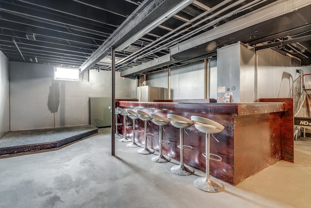 bar with a dry bar and concrete floors