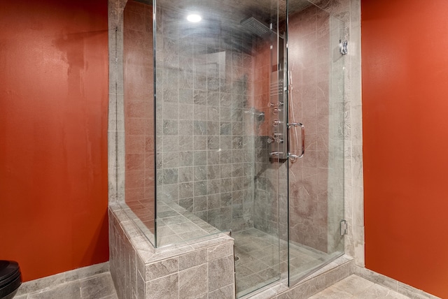 bathroom featuring baseboards and a stall shower