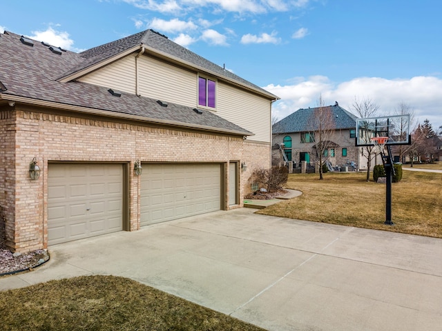 view of home's exterior with brick siding, a shingled roof, concrete driveway, a garage, and a yard