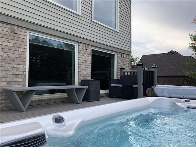 view of pool with a wooden deck and a hot tub