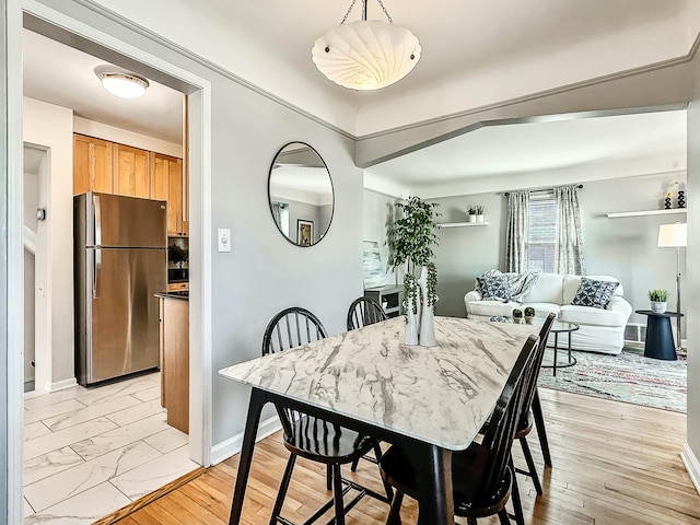 dining area featuring light wood-style floors and baseboards