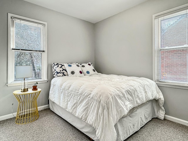 bedroom with baseboards, multiple windows, and carpet flooring