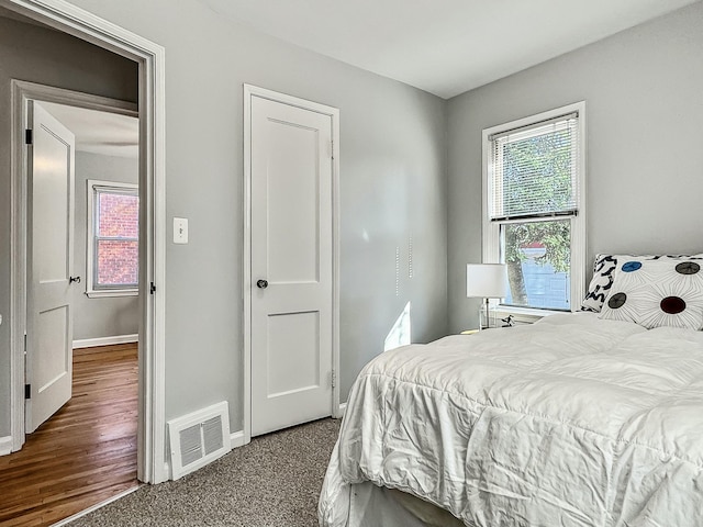 carpeted bedroom featuring visible vents and baseboards