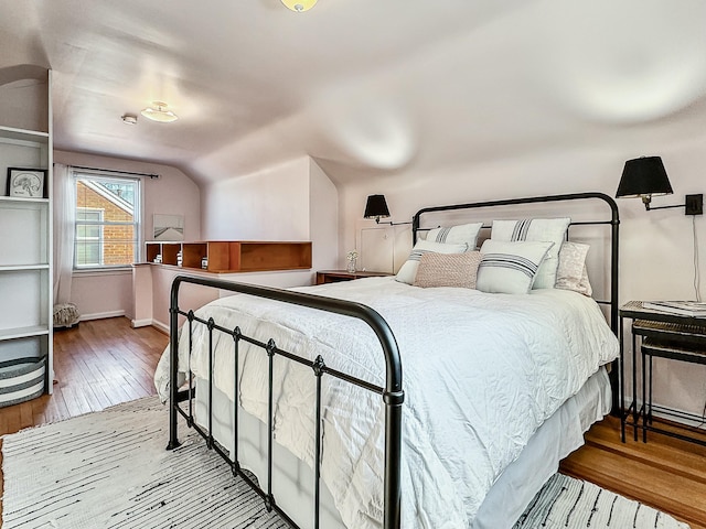 bedroom featuring hardwood / wood-style floors and lofted ceiling