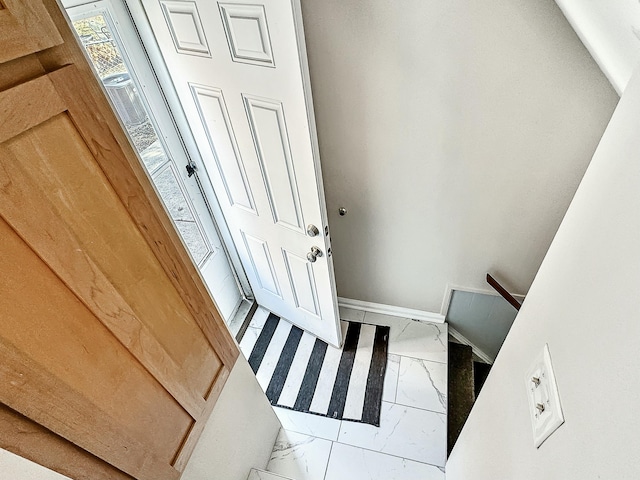 interior space featuring marble finish floor and baseboards