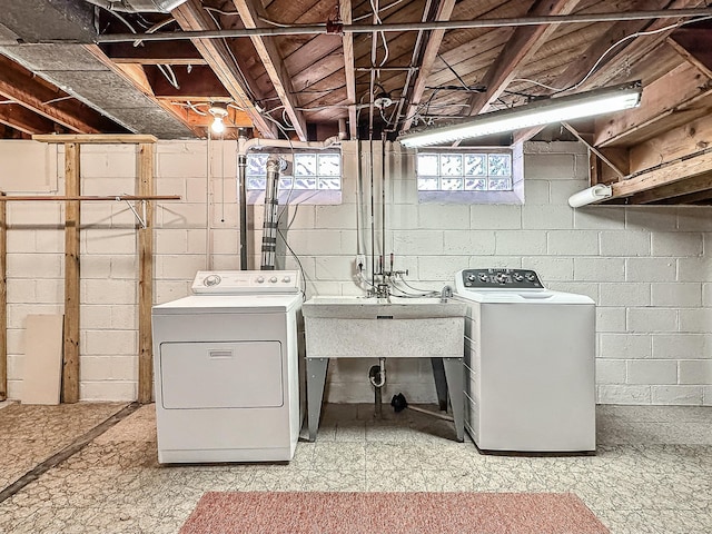 laundry room with washer and clothes dryer, laundry area, light floors, and a sink