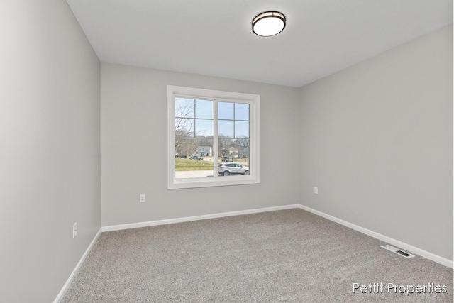 empty room featuring visible vents, baseboards, and carpet floors